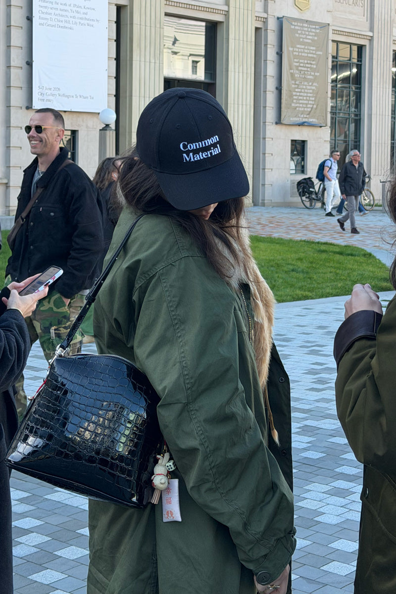 woman in green jacket wearing a black cap